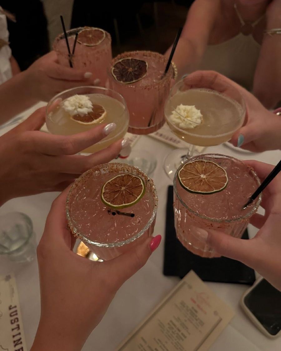 People holding cocktails with decorative elements at a social gathering.