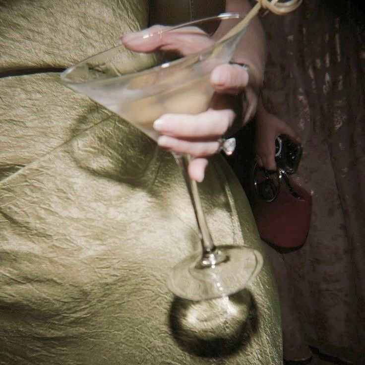 Person holding a martini glass with a blurred background