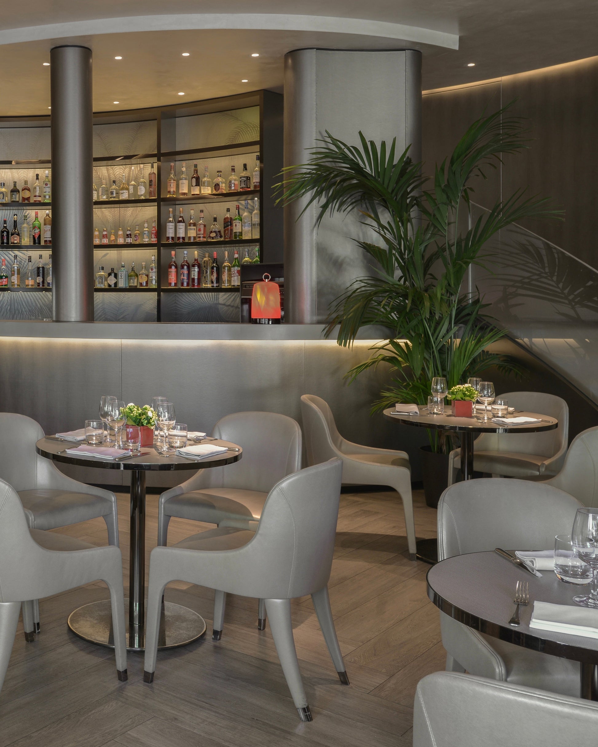 Modern restaurant interior with tables, chairs, and a bar.